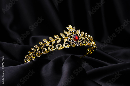 golden crown with rubies on a black silk