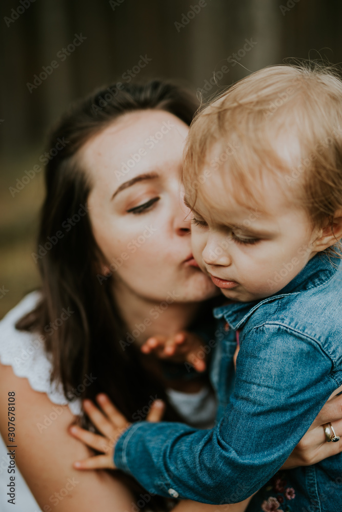 Happy mother and daughter in the park. Beauty nature scene with family outdoor lifestyle. Happy family resting together on the green grass, authentic lifestyle image. Happy mother and daughter in the park. Beauty nature scene with family outdoor lifestyle. Happy family resting together on the green grass, authentic lifestyle image.