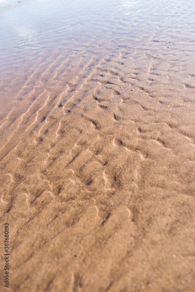 Ripple textures in the sand at sunset on a warm golden beach. random marks in the sand made by the ocean waves power. nature beauty art Ripple textures in the sand at sunset on a warm golden beach. random marks in the sand made by the ocean waves power. nature beauty art