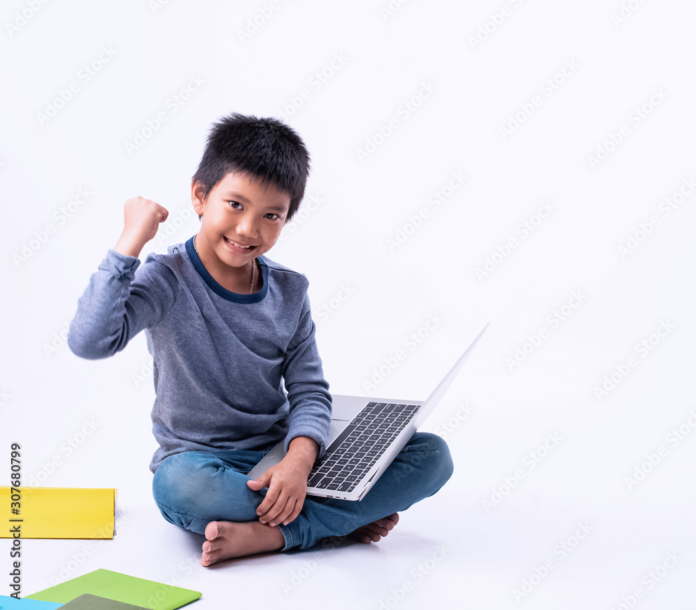 The little boy using laptop for searching data,raise fist up in the air with happy feeling,smart children The little boy using laptop for searching data,raise fist up in the air with happy feeling,smart children