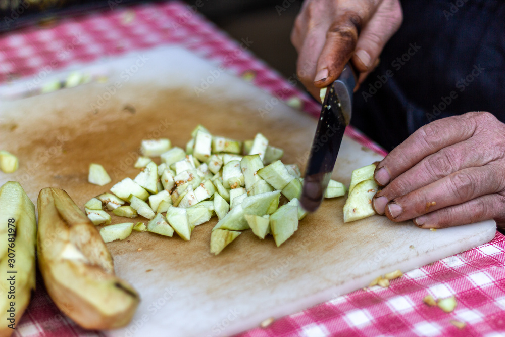 Senior woman hand cutting and chopping eggplant. Real life Senior woman hand cutting and chopping eggplant. Real life