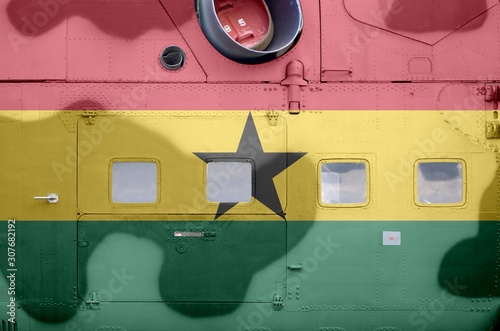 Ghana flag depicted on side part of military armored helicopter closeup. Army forces aircraft conceptual background photo