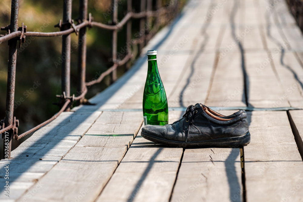 bottle on the suspension bridge and next boots are old worn