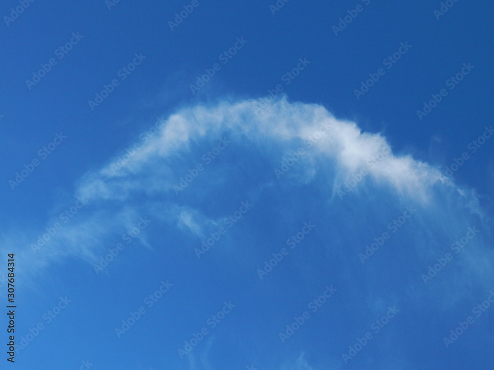 In the dark blue sky a white cloud in the form of an arc In the dark blue sky a white cloud in the form of an arc