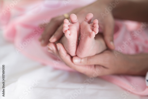 Baby foots on mother hand.Newborn baby feet and relax action with pink blanket.Happy time family concept.