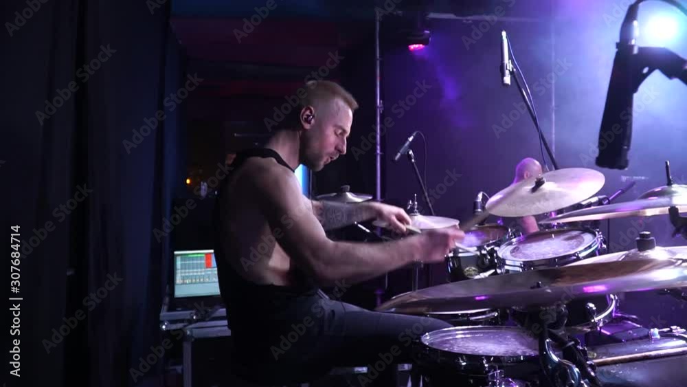 The drummer cool plays the rock concert. The drummer beats the drums on stage. The drummer cool plays the rock concert. The drummer beats the drums on stage. Drummer performing on stage with smoke 