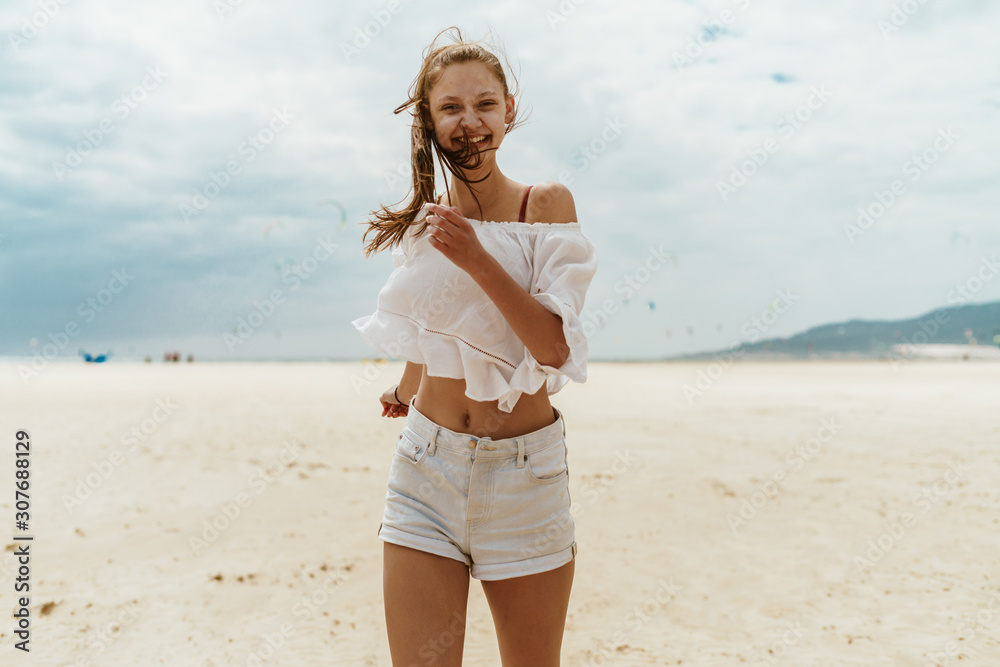 girl in summer clothes laughing joyfully running along the sandy beach girl in summer clothes laughing joyfully running along the sandy beach