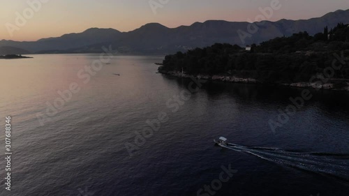 Aerial view tracking a small fishing boat to reveal beautiful sunset over the Adriatic Sea and the Coratian Coast.