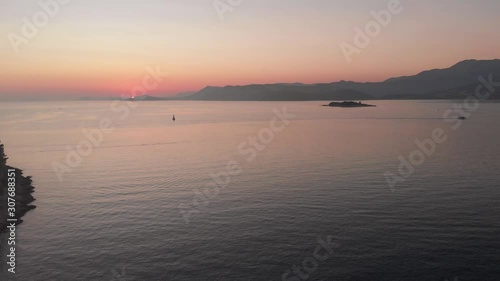 Wide aerial dolly shot of the last of the sunset, calm Adriatic seas, and beautiful seascape of the Croatian Coastline from Cavtat with Supetar Island.