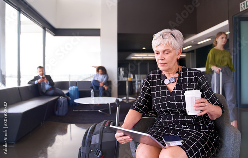 Professional female sitting in airport wearing trendy dress work