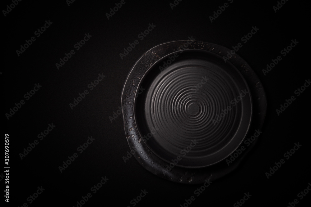 Closeup 2 empty round black aged ceramic plates on dark background with copy space. Concept modern shoot menu, restaurant advert, tableware catalog, top view, copyspace, place for text Closeup 2 empty round black aged ceramic plates on dark background with copy space. Concept modern shoot menu, restaurant advert, tableware catalog, top view, copyspace, place for text