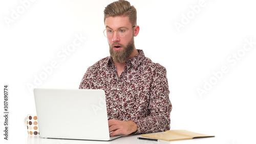 Fotografie Man with beard in flowery pattern shirt can't believe whats happening sitting in front of computer