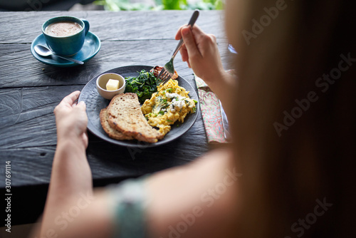 Person on diet eating healthy breakast of scrambled eggs, toast,