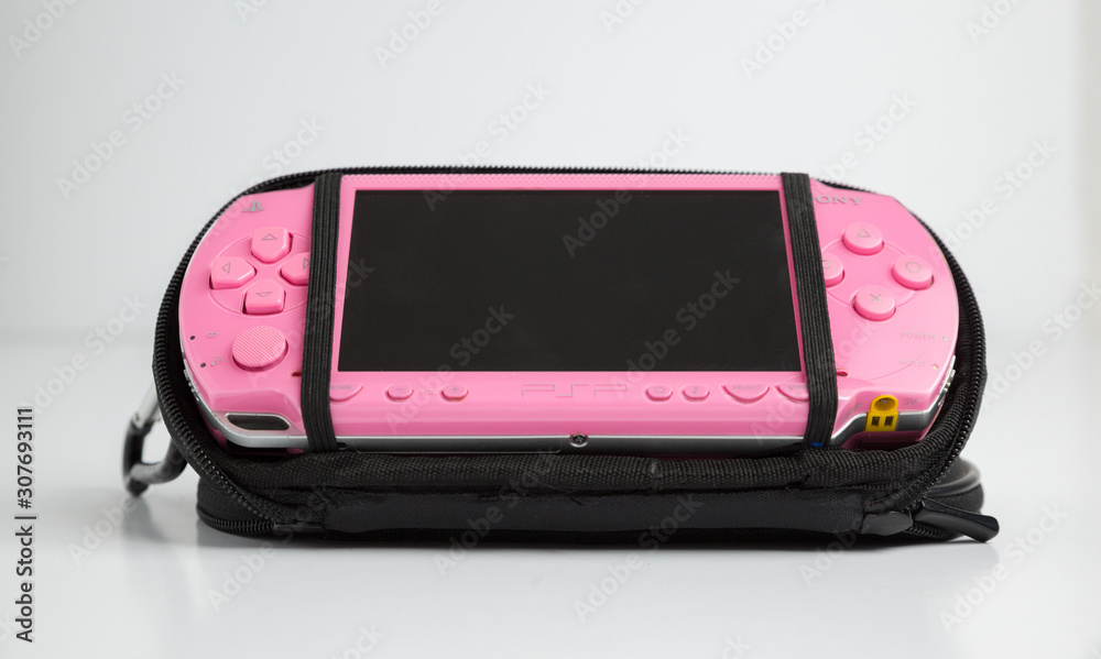london, england, 05/05/2019 A pink sony playstation psp portable games  console. pop 1001. Rare pink edition with blank screen isolated on a white  background. retro vintage gamers computer console. foto de Stock