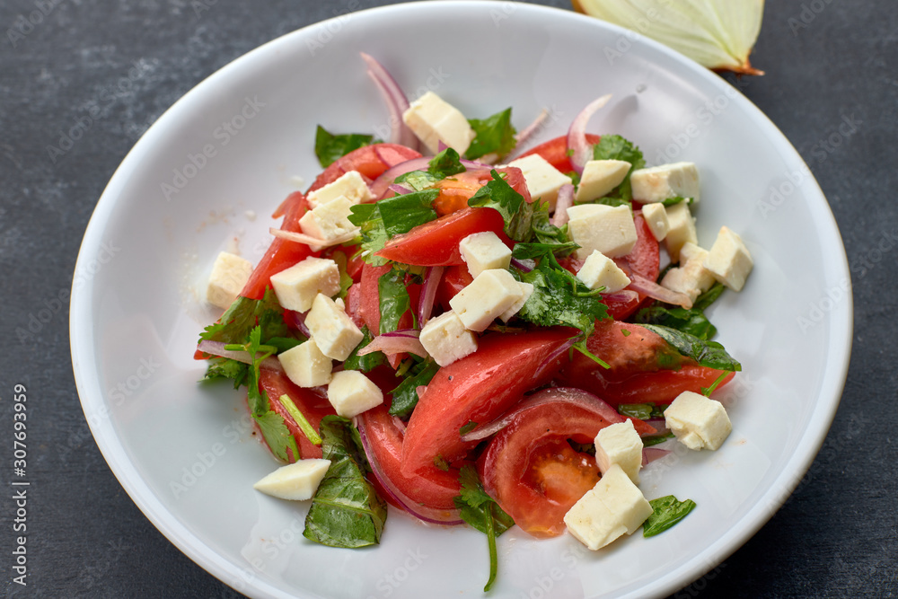 Vegetable salad with cheese, on a white plate