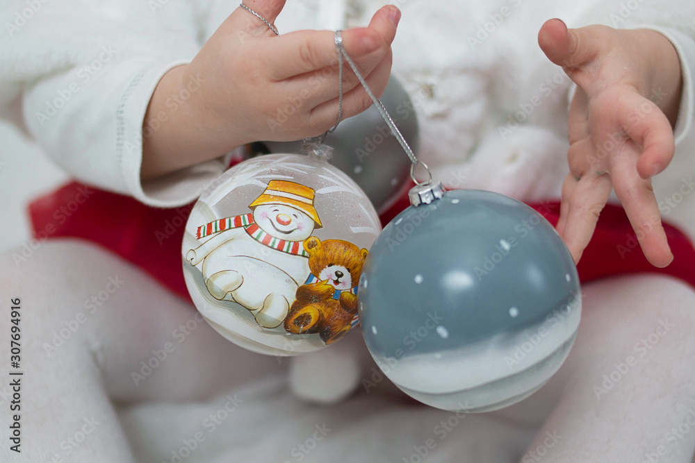 Two large New Year painted glass balls close- up in the hands of a girl Two large New Year painted glass balls close- up in the hands of a girl