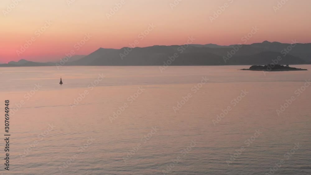 Calm Adriatic Seas from the Croatian coastline from Cavtat. The last of the sunset dipping behind the mountainous backdrop behind the small island of Supetar. Calm Adriatic Seas from the Croatian coastline from Cavtat. The last of the sunset dipping behind the mountainous backdrop behind the small island of Supetar.