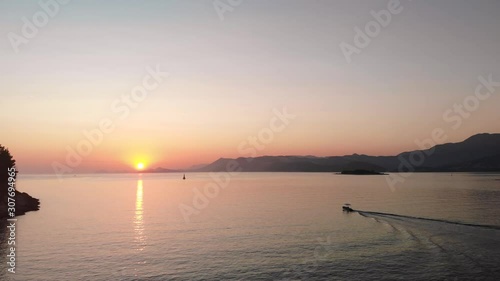 Tracking a small fishing boat over calm Adriatic Seas from the Croatian coastline at Cavtat. The last of the sunset dipping behind the mountainous backdrop behind the small island of Supetar.