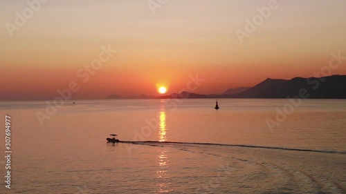 Beautiful sunset center frame with a fishing boat on the Adriatic Sea. Aerial view from the Croatian coastline from the town of Cavtat.