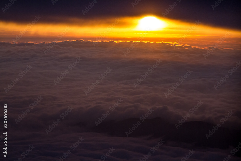 Dawn seen from the sky amid clouds.