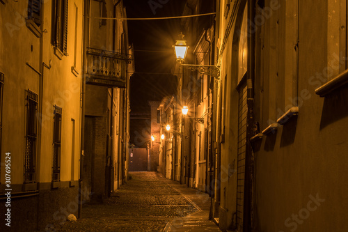 Fototapeta Naklejka Na Ścianę i Meble -  atmosphärische Stimmung in beleuchteter Straße bei Nacht
