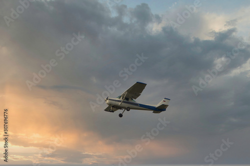cessna plane flying at sunset in the clouds