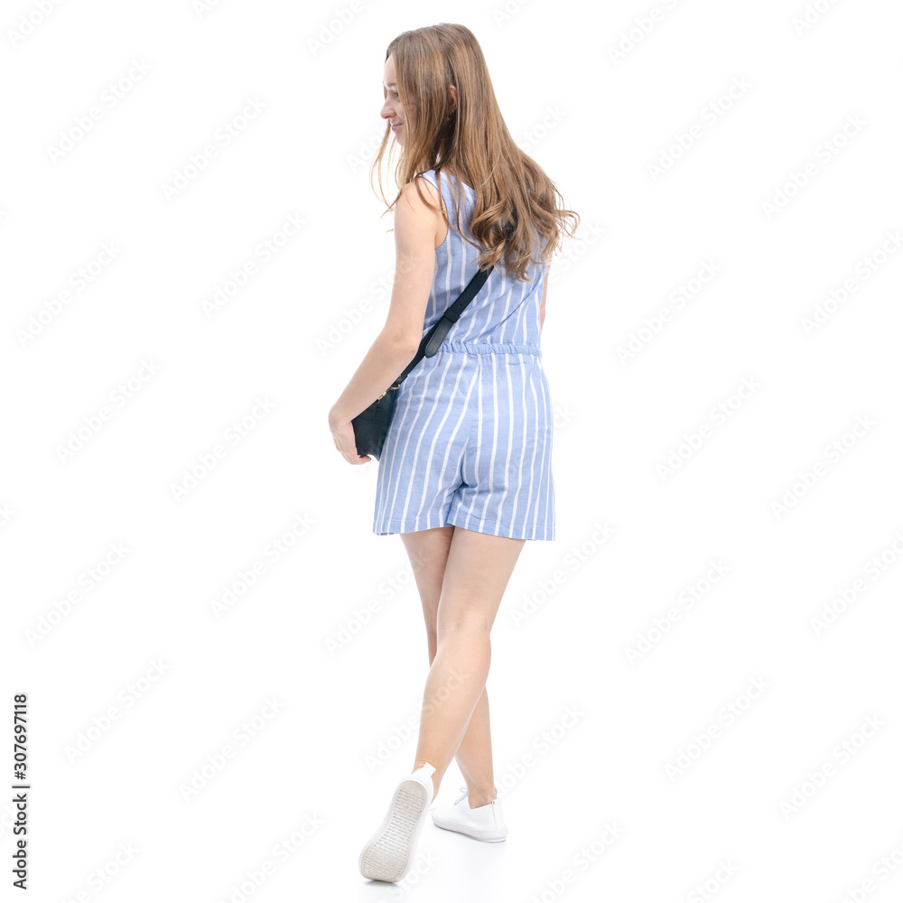 Woman in blue overalls with black bag fashion goes walking smiling on white background isolation, back view Woman in blue overalls with black bag fashion goes walking smiling on white background isolation, back view