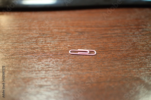 pink paper clip on a dark office desk
