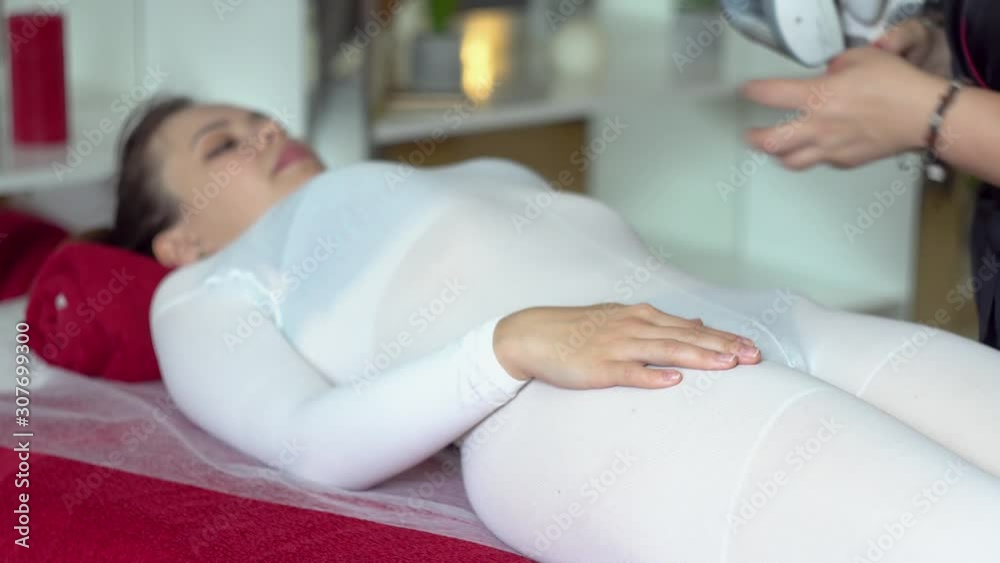Beautician makes anti-cellulite massage to a patient. Girl on LPG massage session in beauty salon Beautician makes anti-cellulite massage to a patient. Girl on LPG massage session in beauty salon