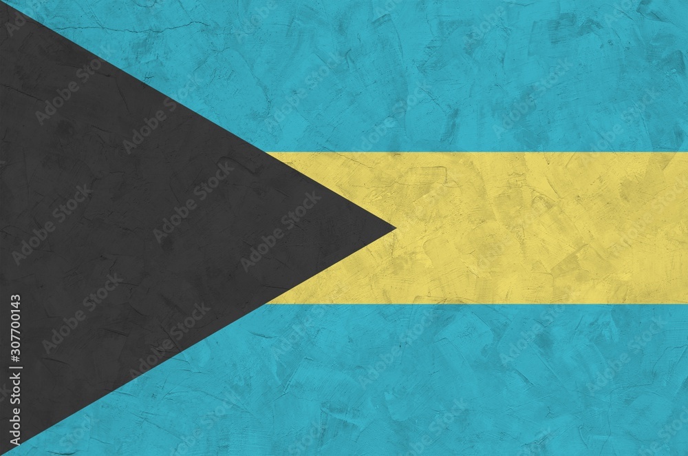 Bahamas flag depicted in bright paint colors on old relief plastering wall. Textured banner on rough background