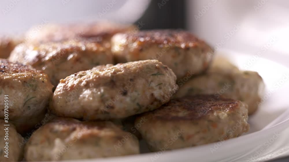 Pile of fried chicken cutlets on plate rotating in microwave. Pile of fried chicken cutlets on plate rotating in microwave.