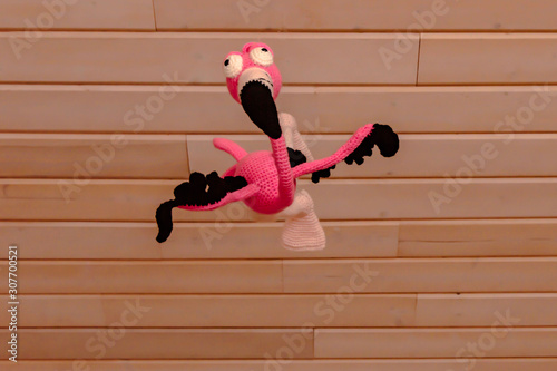 Amigurumi doll flamingo bird in flight photo