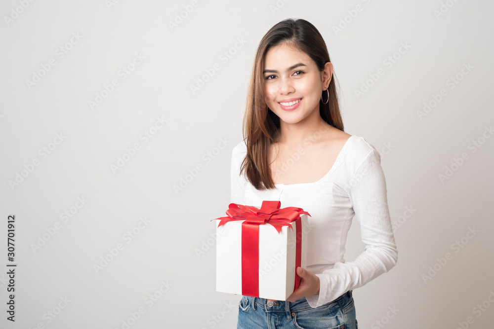 Beautiful woman is holding gift box on white background Beautiful woman is holding gift box on white background
