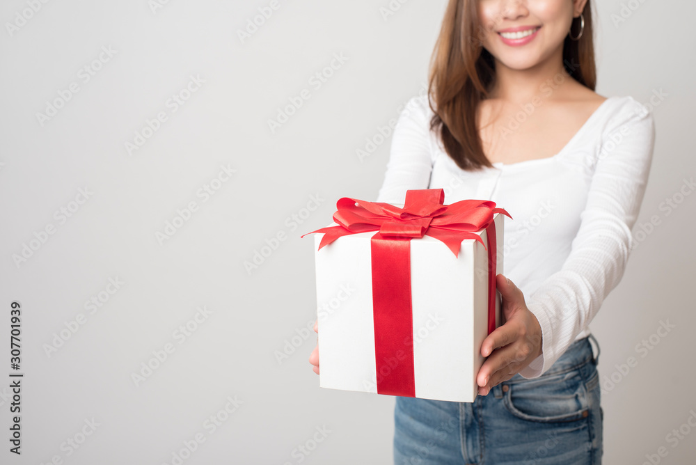 Beautiful woman is holding gift box on white background Beautiful woman is holding gift box on white background