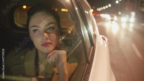 Young brunette Businesswoman in the taxi is reading messages on her tablet photo