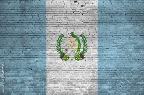 Guatemala flag depicted in paint colors on old brick wall. Textured banner on big brick wall masonry background photo