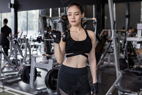Asian women with dumbbells in the gym.
