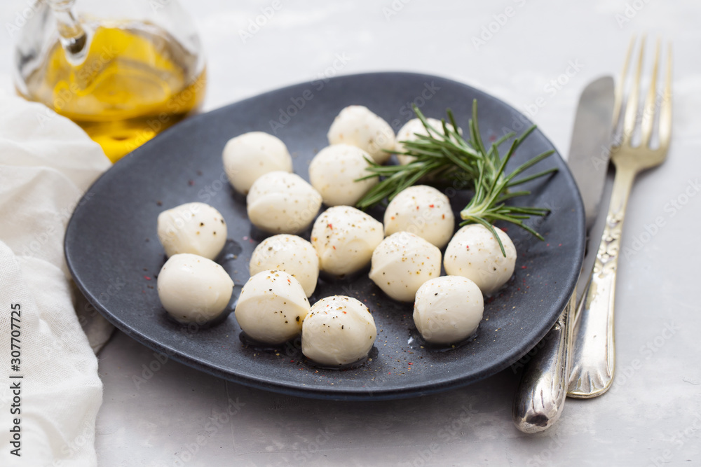 mozarella with pepper on black plate on ceramic background