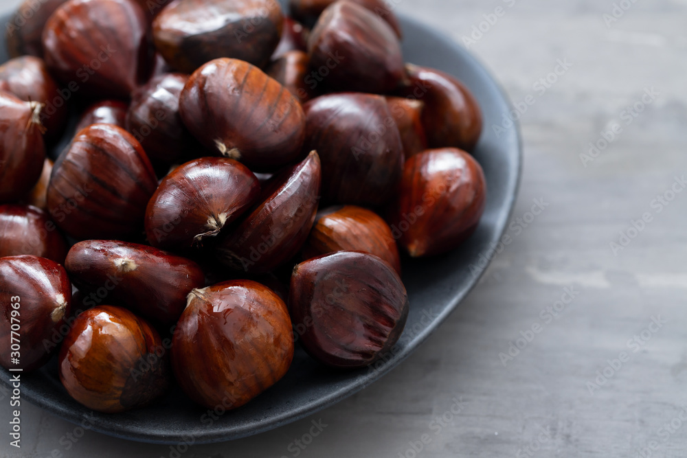 fresh chestnuts on dish on ceramic background fresh chestnuts on dish on ceramic background
