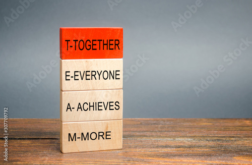 Wooden blocks with the word Together, Everyone, Achieves, More. Teamwork and team concept. Community, support, partnership. Achieving a common goal. Cooperation and business strategy photo