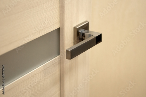 Stylish metal door handle close-up. © pushann