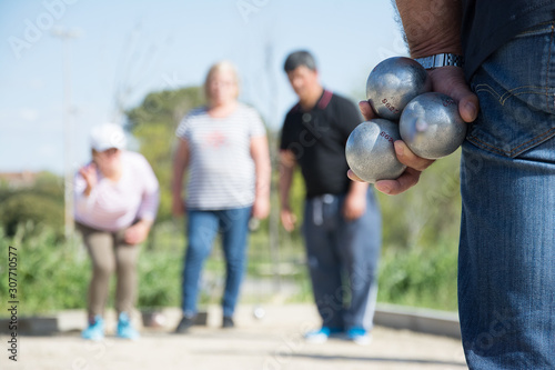 Senior people playing bocce in a park