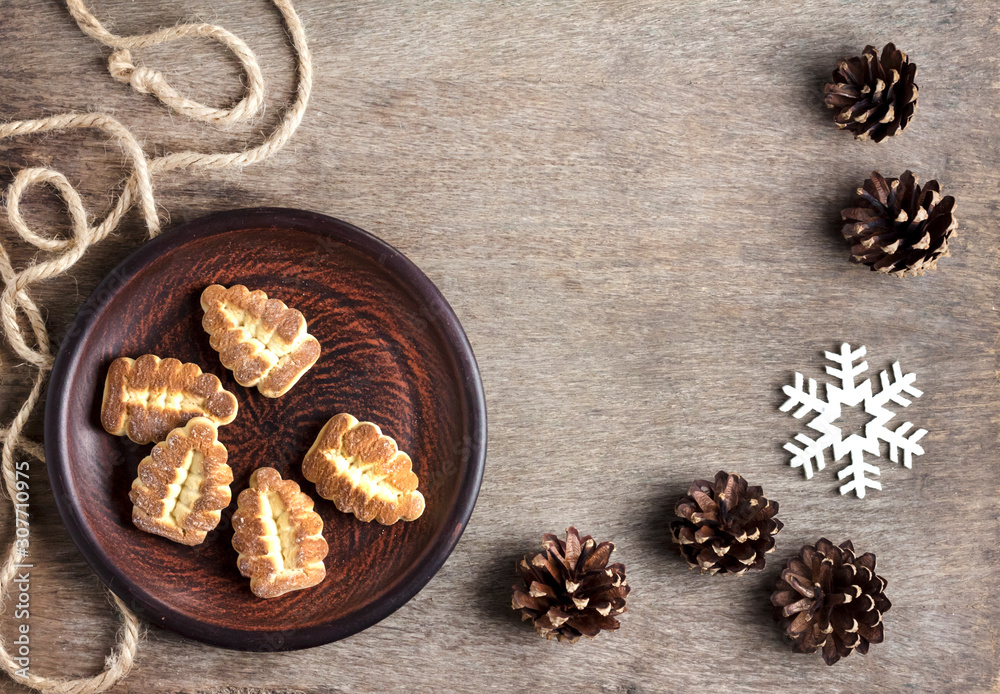 Rustic winter composition with shortbread cookies on a plate and pinecones Rustic winter composition with shortbread cookies on a plate and pinecones