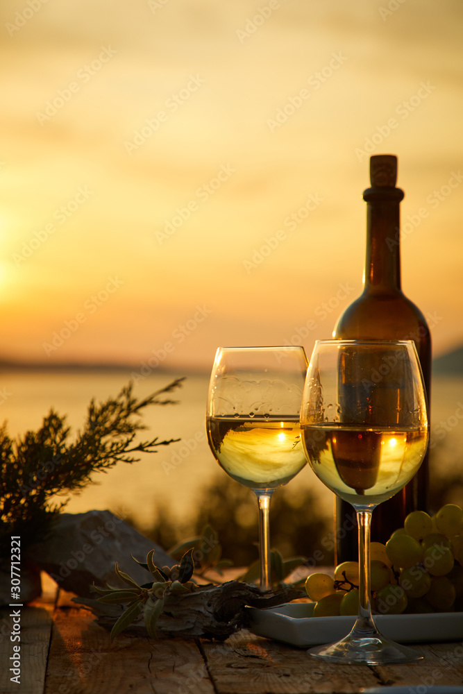 two glasses with wine during sunset time