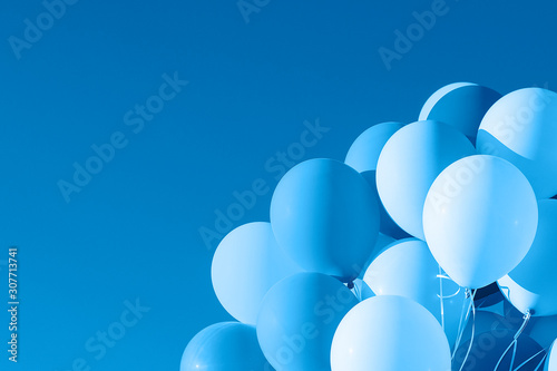 Color of 2020 year, classic blue. Group of balloons with helium on the sky background. Trend color. photo