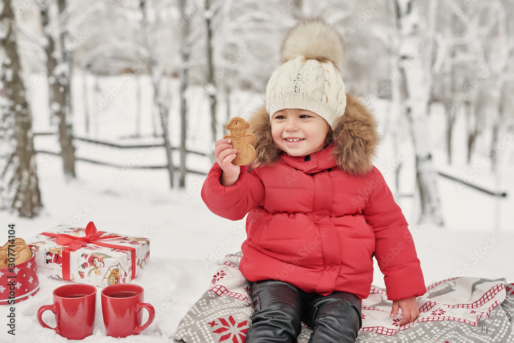Happy child girl on winter walk outdoors drinking tea. smiling baby little child playing in winter Christmas holidays. Christmas family in winter park. Girl in winter forest. ..