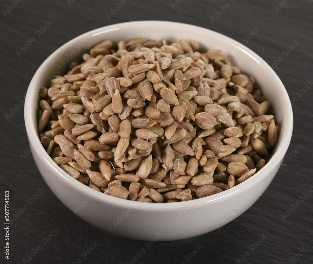 sunflower seeds in bowl on white background sunflower seeds in bowl on white background