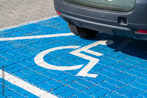 Foto Vehicle on a fresh blue painted parking spot for people with functional impairment