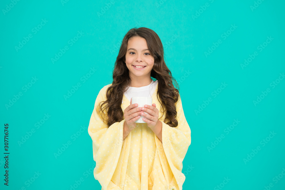 Morning or evening. feeling comfortable at home. happy girl with tea cup. good morning drink. small kid blue background. little girl drink cocoa or milk before sleeping. cosy and fluffy pajama Morning or evening. feeling comfortable at home. happy girl with tea cup. good morning drink. small kid blue background. little girl drink cocoa or milk before sleeping. cosy and fluffy pajama