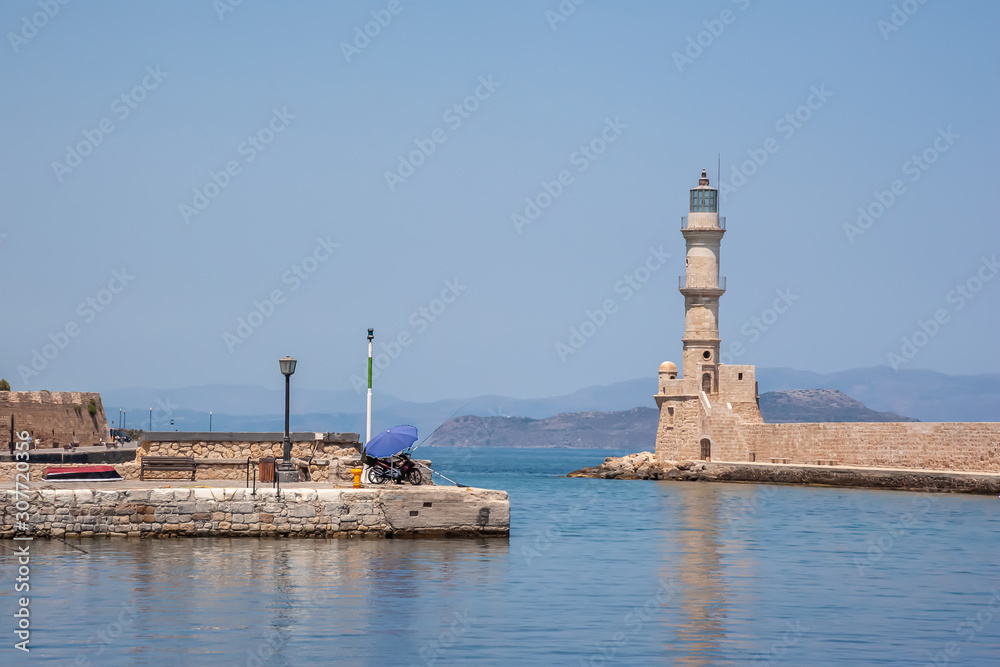 The promenade in the city of Chania on the background of a lighthouse and houses